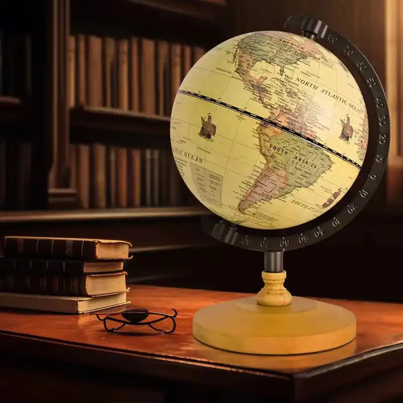 Vintage-style world globe on a wooden desk with books in the background