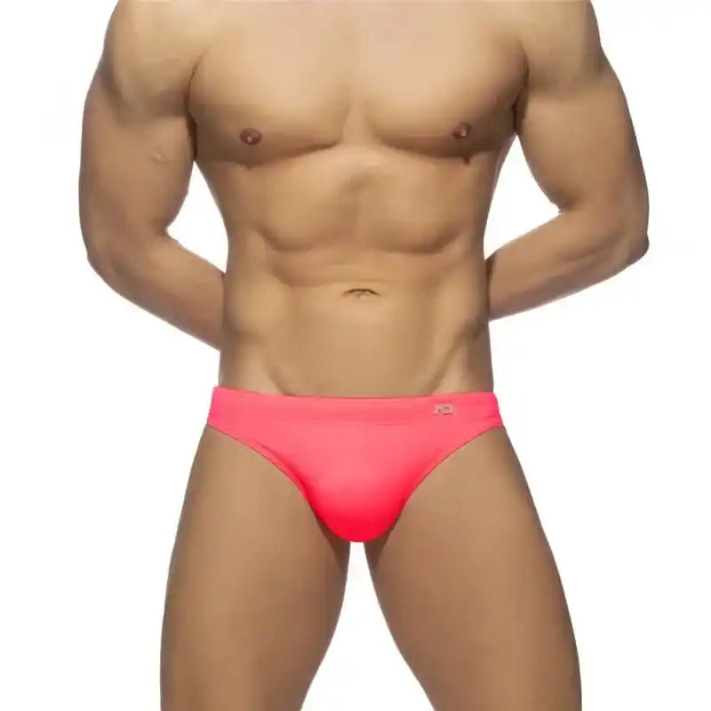 Men's neon pink swim briefs with push-up pouch and snug sunga fit, perfect for vibrant beachwear or poolside looks.