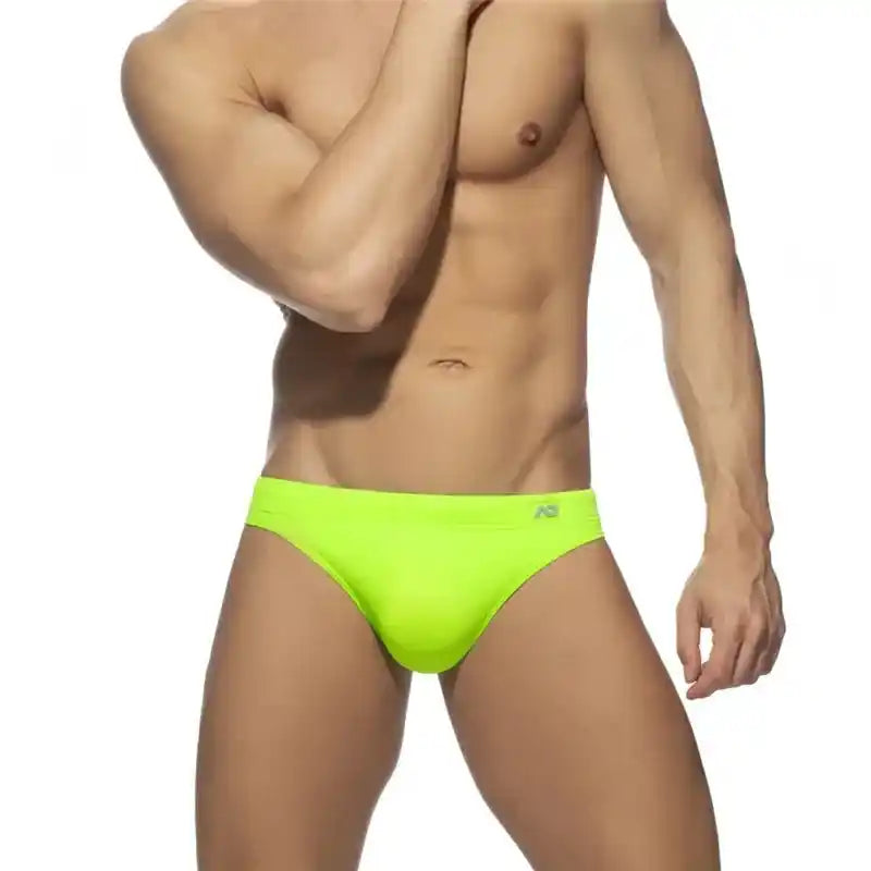 Men's neon green swim briefs with push-up pouch and low-rise sunga style, ideal for standout summer swimwear fashion.