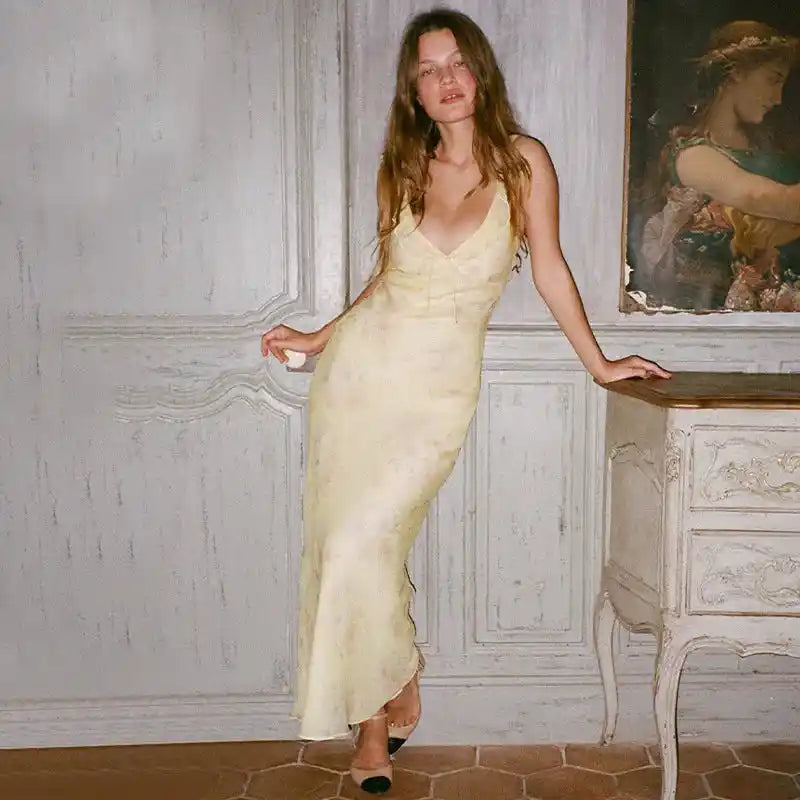 Indoor look of Cryptographic yellow floral plunge maxi dress with fairycore aesthetic, styled with vintage decor.