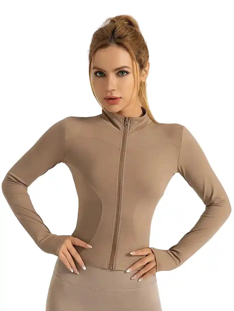 Beige women's tight-fitting yoga jacket with long sleeves and zipper closure, ideal for stylish fitness and sportswear.